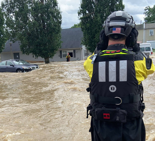 Rescuer wearing the Water Ops Rapid Deployment Bag near flooded river